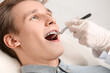Handsome man with dental braces visiting orthodontist in clinic, closeup