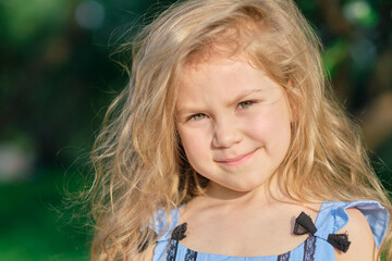 Little girl smiles at the camera. pretty girl posing for a photo and holding two green fresh apples in her hands