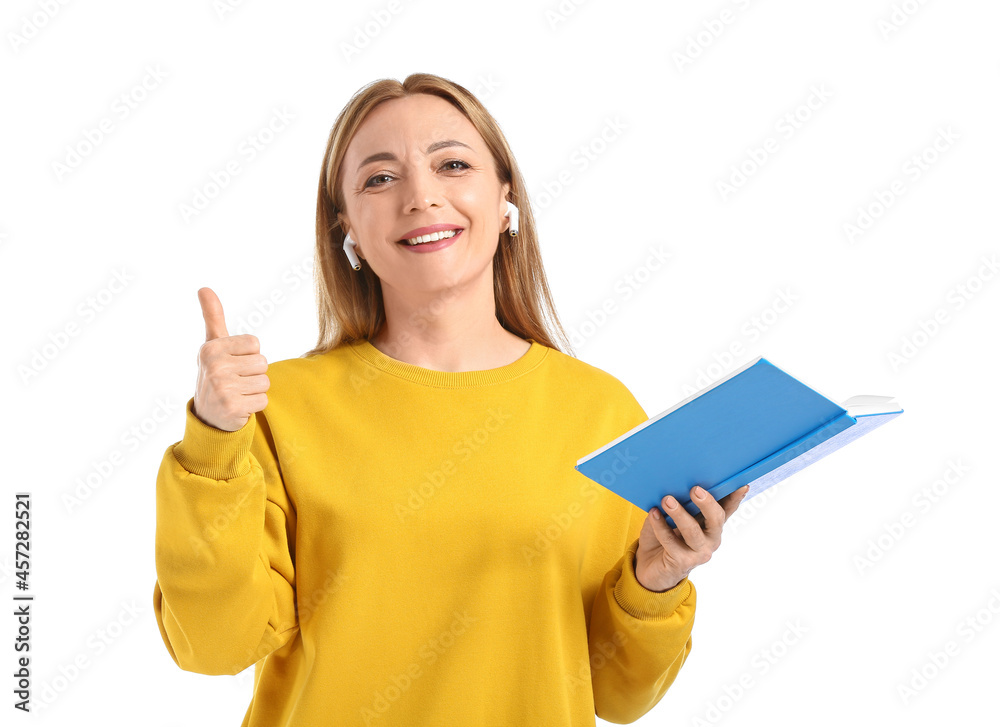 Mature woman with book showing thumb-up on white background