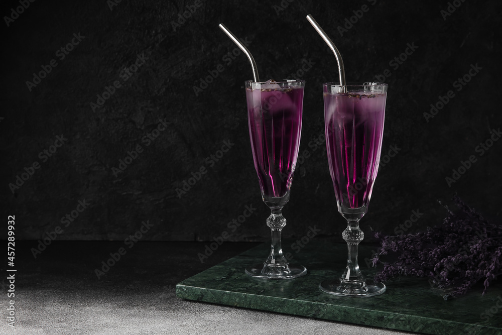 Glasses of fresh cocktail with lavender on dark background