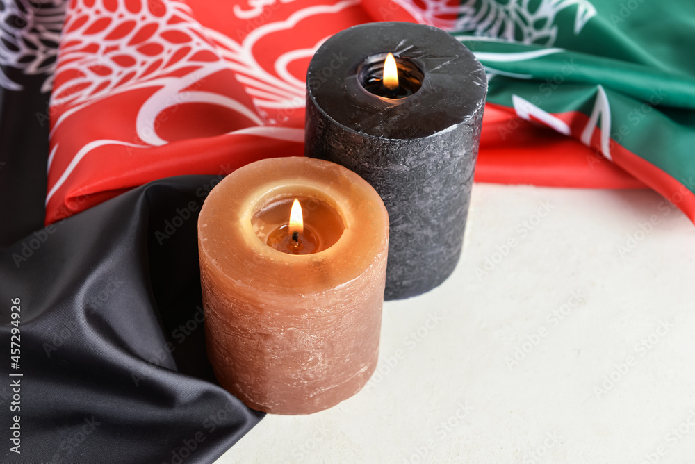 Burning candles and flag of Afghanistan on table