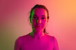© Lustre Art Group  - One young caucasian girl attentively looking at camera isolated over gradient studio background in neon lights
