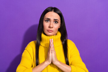 Poster - Portrait of young pleading girl arms palms together look camera sullen face isolated on purple color background