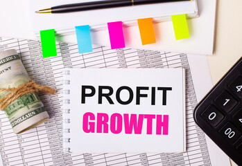 Fototapete - On a light background, a pen, dollars, a notebook with the text PROFIT GROWTH and bright stickers. Business concept