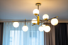 Modern Designed Chandelier With Burning Lamps. Contemporary Interior.