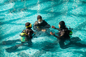 Wall Mural - Instructor and divers in aqualungs, dive course