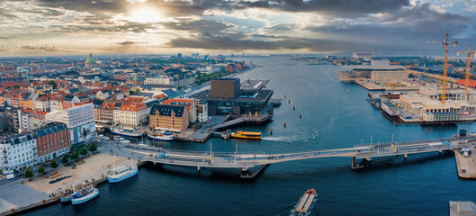 Wall Mural - Beautiful canals of Copenhagen, the capital of Denmark. Magical summer view of Copenhagen city narrow streets, buildings, pedestrian bridges and boats down the canals.