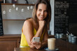 © ksenija1803z - portrait of smiling woman in cafe with cup of coffee and smartphone