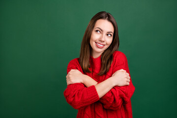 Poster - Photo of young cheerful girl happy positive smile hug cuddle herself dream look empty space isolated over green color background