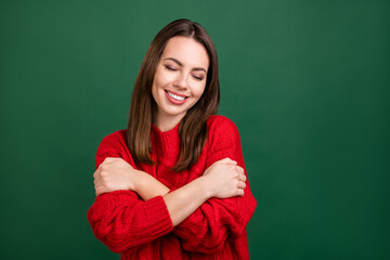 Sticker - Photo portrait girl in red pullover dreamy embracing herself smiling isolated green color background