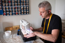 A Tailor Working With His Sewing Machine In His Small Workshop Set Up
