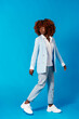 © Cavan Images - Portrait of fashionable african woman standing on blue background