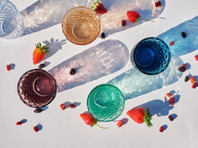 Top View Of Colorful Glasses And Shadows And Berries