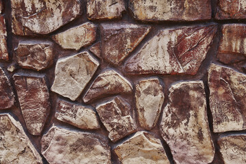 Tidy inlaid stone wall forming a decorative residential pattern