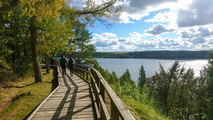 Canvas Print - Cute couple walking on a boardwalk by the lake on a sunny day