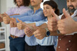 © Studio Romantic - Group of happy satisfied business people giving thumbs-up all together. Team of smiling confident men and women proud of good results doing OK gesture, hands close up. Success and satisfaction concept