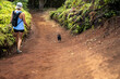 © Cavan - Blonde woman going on a hiking adventure with small black puppy