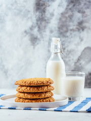 Wall Mural - homemade oatmeal cookies on a light background with milk in a gl