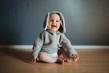 Cute Smiling Baby Boy Wearing A Bunny Jumper With Ears For Easter