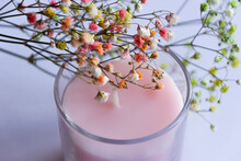 Pink Candle Covered With The Dried Flowers On White Background