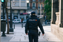 Policewoman Member Of The Spanish Security Forces And Bodies Walking Down A City Street