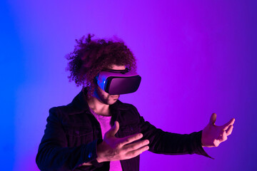 Surprised young latin man with afro hair with virtual reality headset