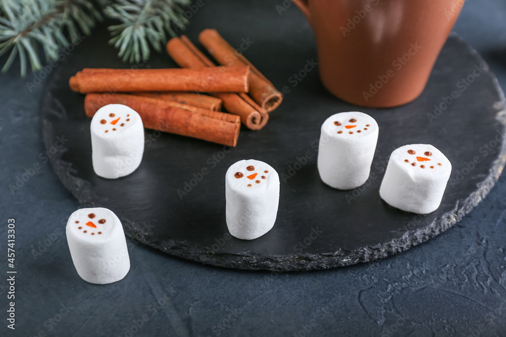 Snowmen made of soft marshmallows on dark background