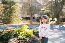 Little Girl Standing In Her Driveway With A Wide Smile For Camera