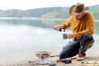© Cavan Images - Man preparing barbecue on brazier in nature