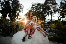 Sisters Posing On Giant Rock In Desert Garden In San Diego