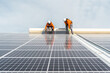 © Cavan Images - Unrecognizable solar panel technicians teamworking in Spanish factory