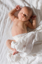 Newborn Baby Sleeping On White Bed With White Sheets