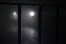 Spooky Night Time Fog Around A Cobweb Under Railings With Dew On It
