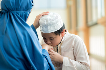 Wall Mural - Concept Eid Mubarak, Picture of a Muslim boy in Islam following his mother with love at the mosque after prayer.