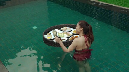 Wall Mural - cheerful young woman enjoying with floating food and champagne glass in swimming pool