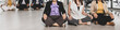© Bangkok Click Studio - Six asian business women sitting on the floor in office with multiple glass windows meditating beside conference tables