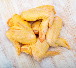 Wall Mural - Ingredients for cooking. Fresh raw farmer chicken wings on light wooden surface