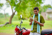Indian Farmer Sitting On His New Bike And Showing Money.