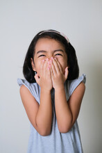 Asian Little Girl Showing Shy Gesture With Her Hand Cover Mouth
