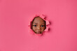 © Lisa Tichané - Little girl’s face peeking through pink torn paper