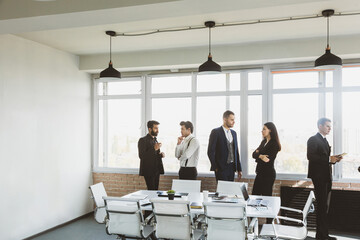 Wall Mural - Silhouettes of people against the window. A team of young businessmen working and communicating together in an office. Corporate businessteam and manager in a meeting.