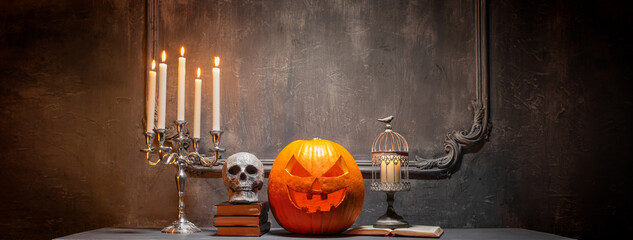 Wall Mural - Scary laughing pumpkin and old skull on ancient gothic fireplace. Halloween, witchcraft and magic.