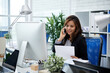 © DragonImages - Pretty smiling female entrepreneur talking on phone with colleague from another department when looking at sales report in her hands
