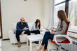 © Andrii - A young married couple of men and women talk to a psychologist at a therapy session. Psychology.
