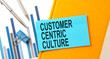 Customer centric culture text on sticker on the yellow notebook with chart and pen