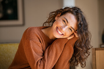 Fototapete - Young woman laughing while relaxing at home