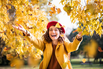 Fototapete - Young playful woman playing with leaves in autumn