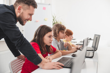 Wall Mural - teacher and kids having programming lesson in school