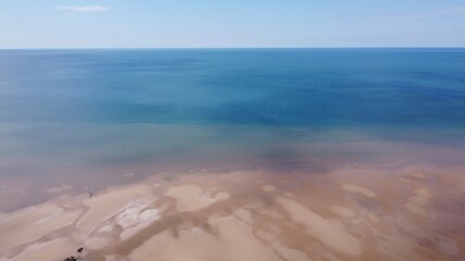  Drone image of a sandy beach with blue sea and a blue sky background. Taken in Lytham England. 