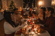 © Syda Productions - holidays and celebration concept - multiethnic group of happy friends with sparklers having christmas dinner at home